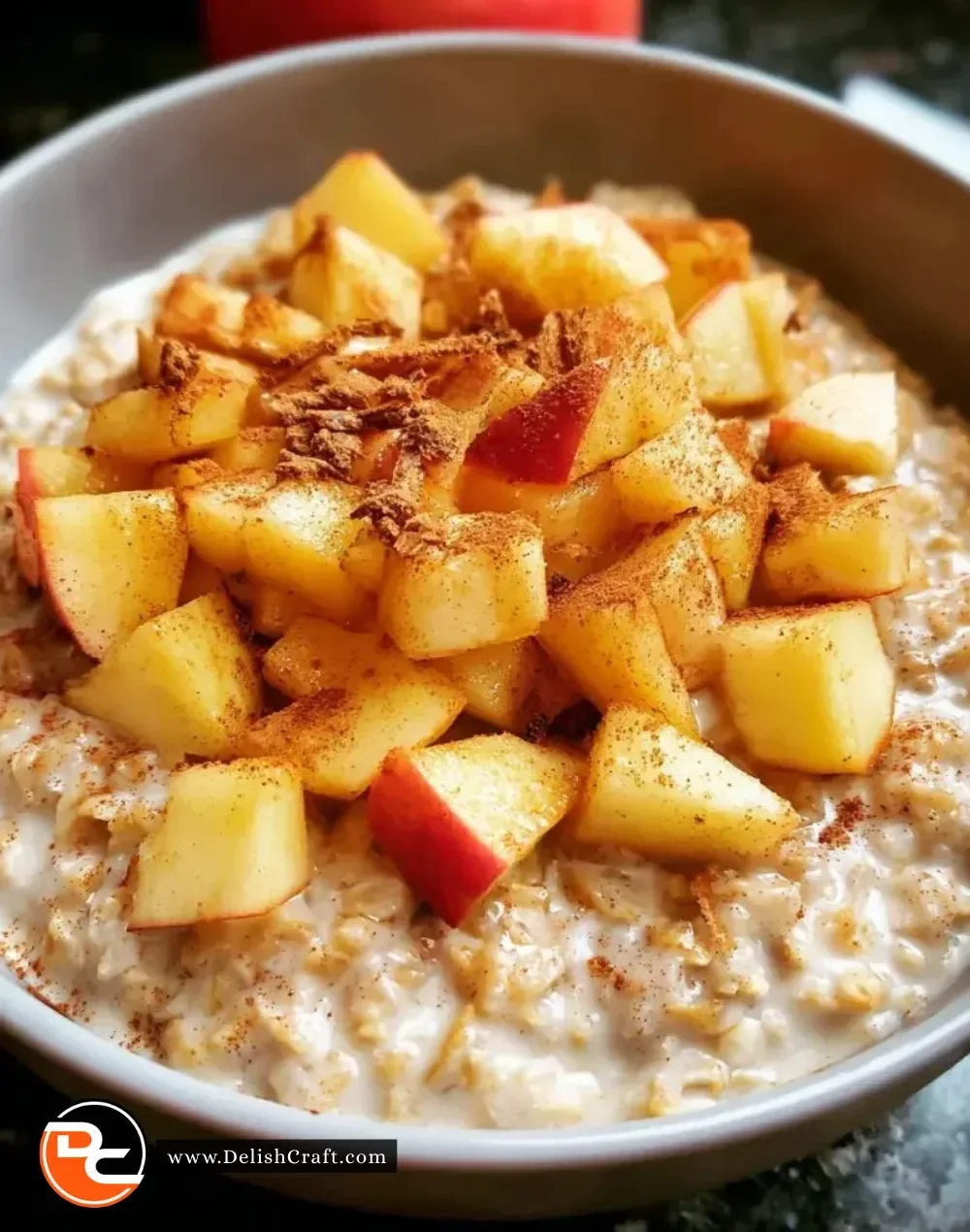 Bowl of warm Apple Cinnamon Oatmeal topped with fresh apples and cinnamon