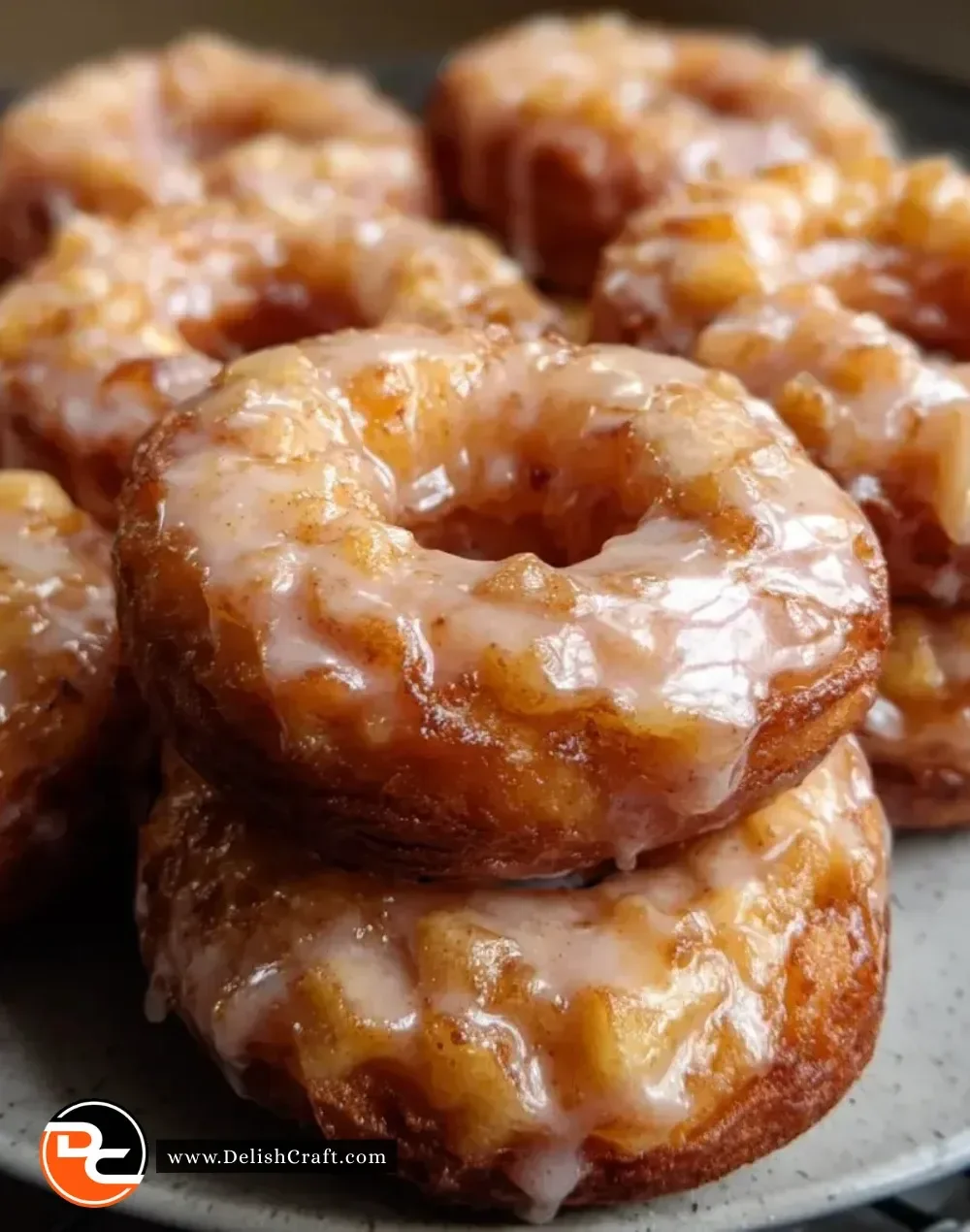 Freshly baked apple donuts drizzled with sweet glaze on a wooden table