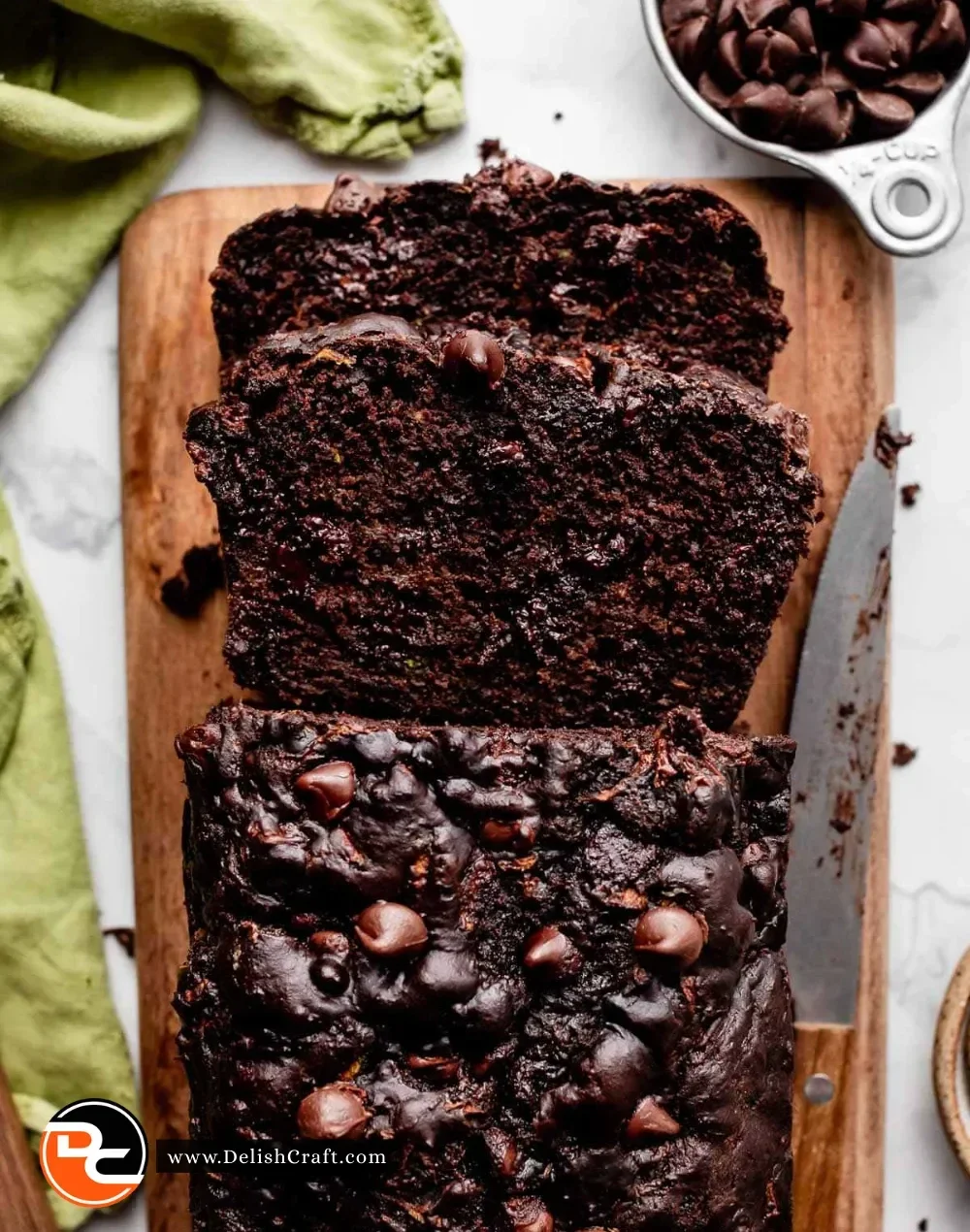 Moist double chocolate zucchini bread slice on a wooden board