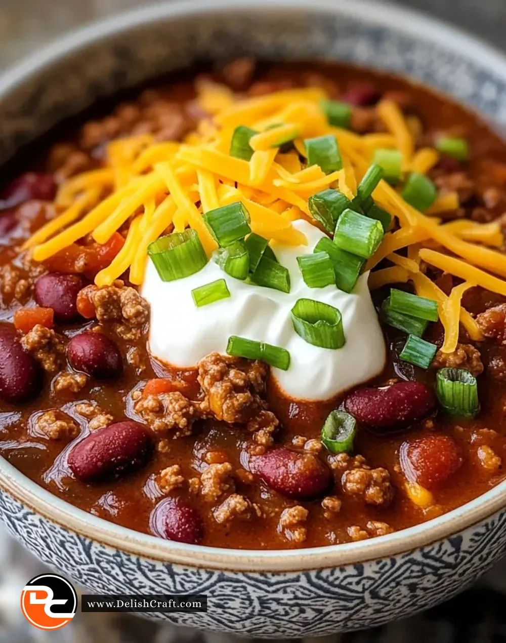 A bowl of the best chili recipe topped with fresh herbs and cheese.