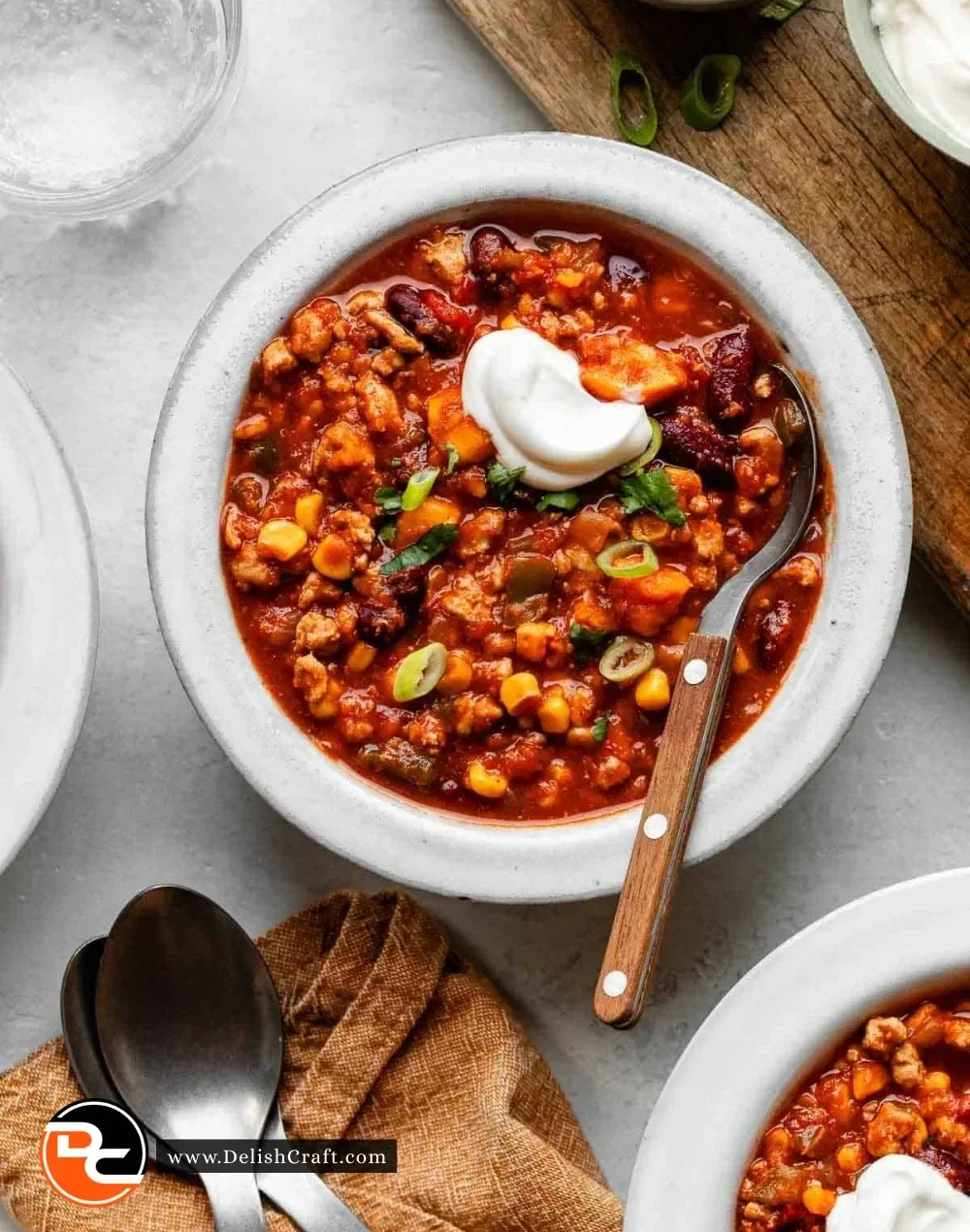A bowl of Turkey Sweet Potato Chili garnished with fresh herbs