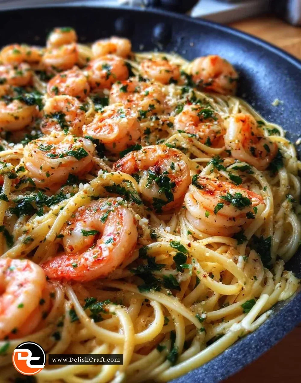Plate of delicious garlic butter shrimp pasta with fresh herbs and garlic sauce.