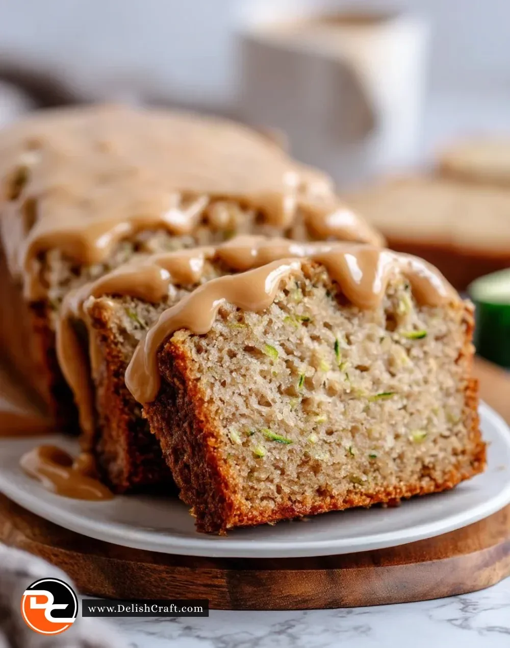 Freshly baked apple zucchini bread with brown sugar frosting on a wooden table