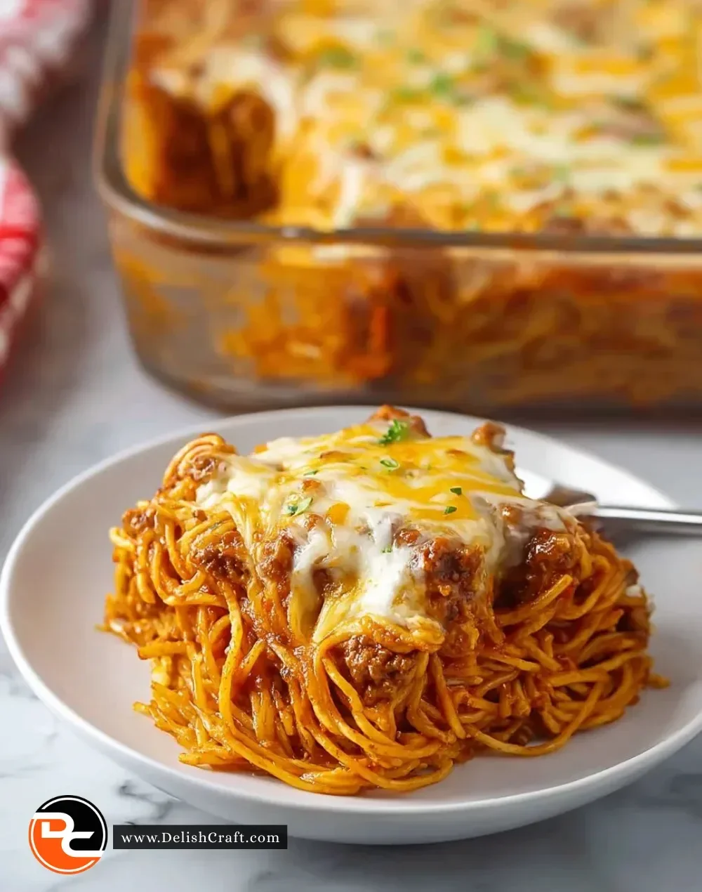 Baked Cream Cheese Spaghetti Casserole topped with cheese and herbs
