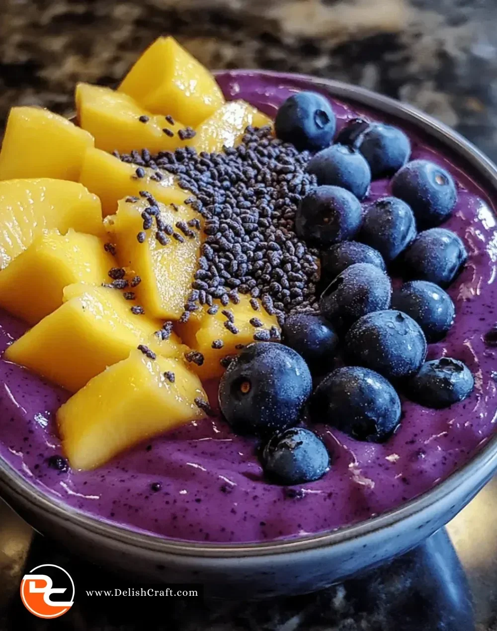 Delicious mango blueberry smoothie bowl topped with fresh fruit and granola