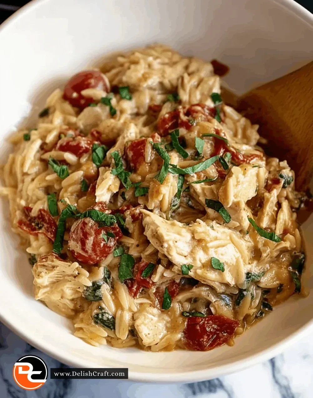 Delicious bowl of Classic Crockpot Tuscan Chicken Orzo garnished with herbs
