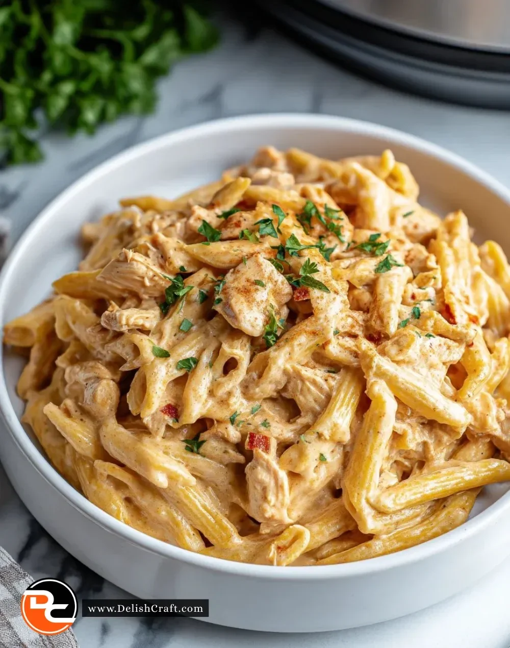 Crock Pot Creamy Cajun Chicken Pasta served in a bowl with fresh herbs