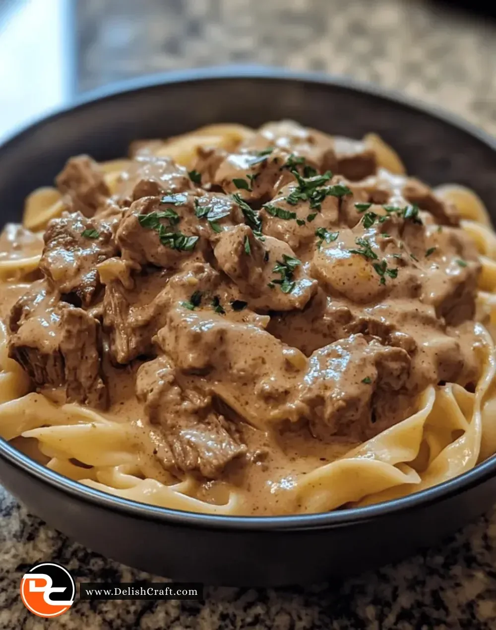 Easy Instant Pot Beef Stroganoff served in a bowl with noodles and garnished with parsley