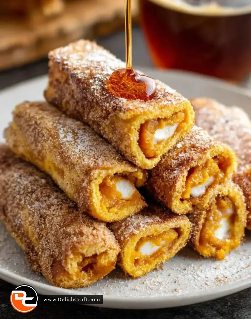Delicious Pumpkin French Toast Roll-Ups served with maple syrup on a plate
