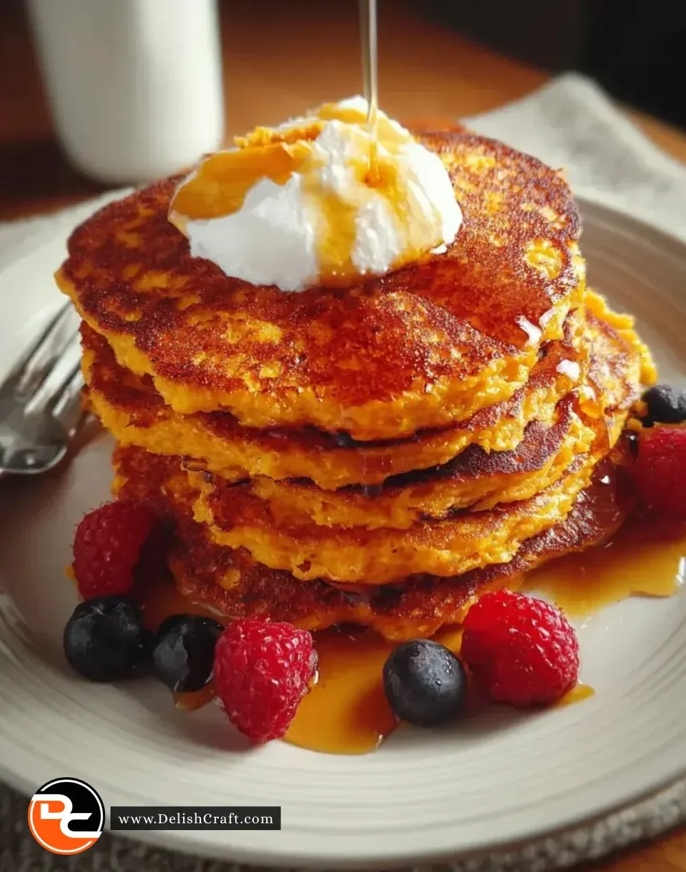 Golden-brown sweet potato pancakes topped with syrup and fresh fruit