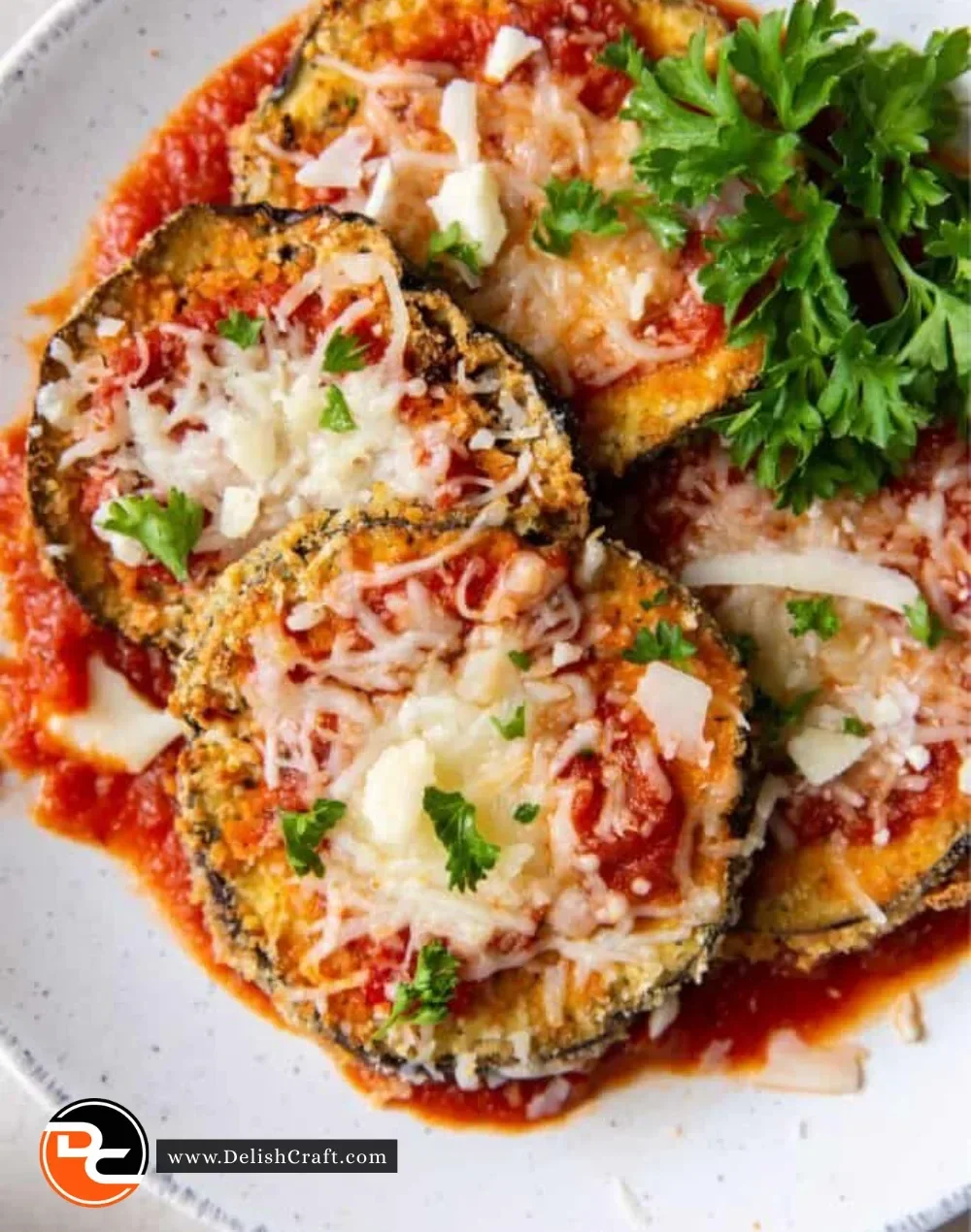 Crispy Air Fryer Eggplant Parmesan served on a white plate with fresh basil.