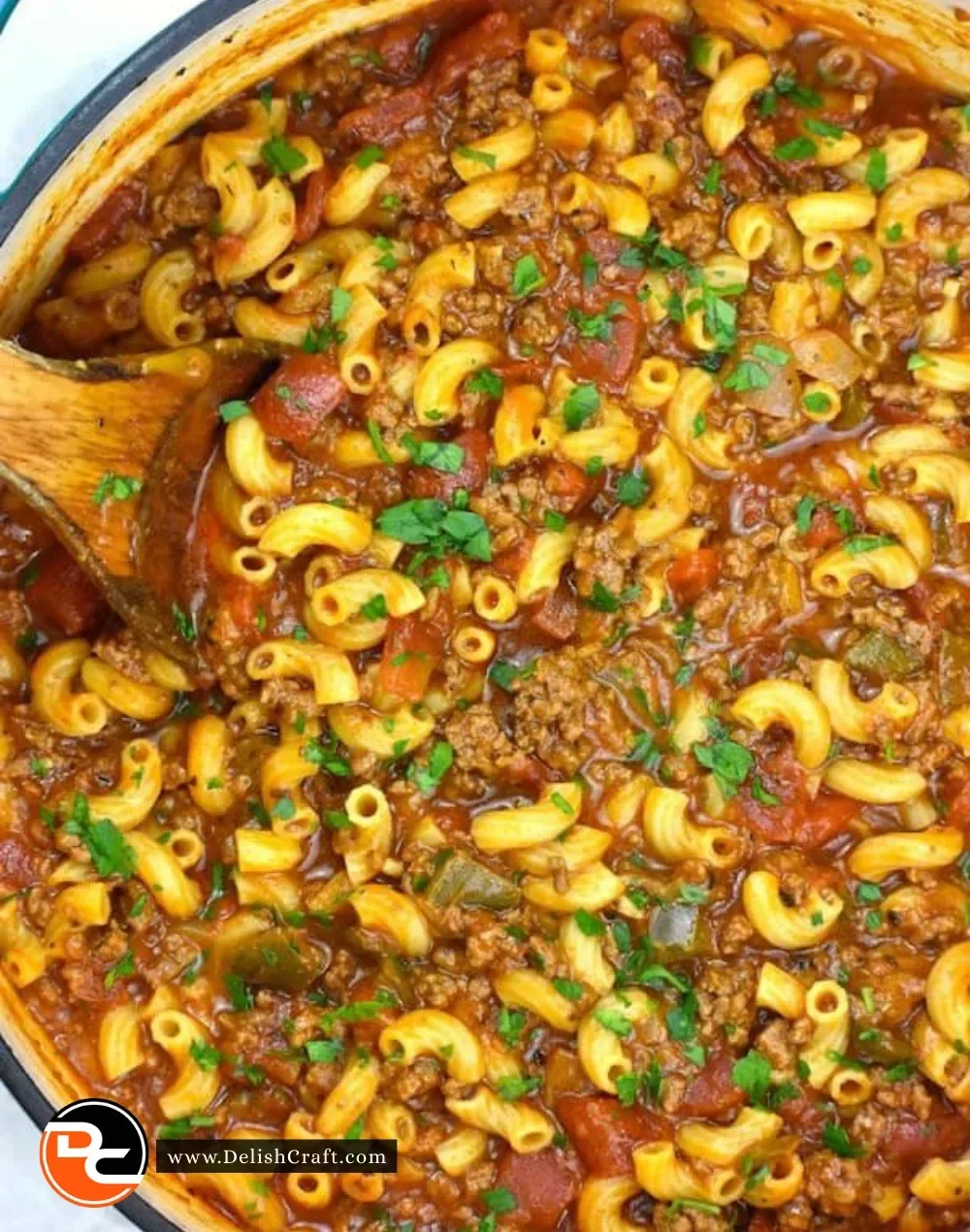 Delicious bowl of American Goulash topped with cheese and herbs.