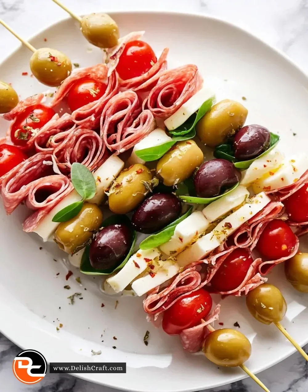 Colorful antipasto skewers with meats, cheeses, and vegetables on a platter.