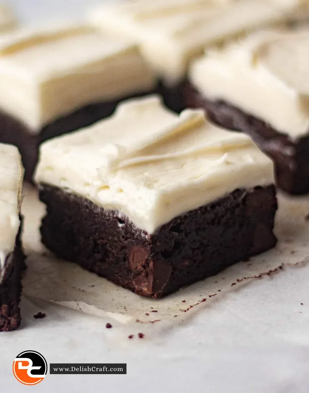 Delicious brownies with cream cheese frosting on a white plate
