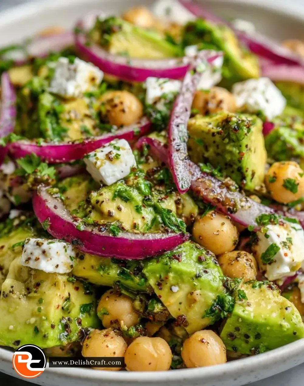 Chickpea Feta Avocado Salad in a bowl with fresh vegetables and toppings.