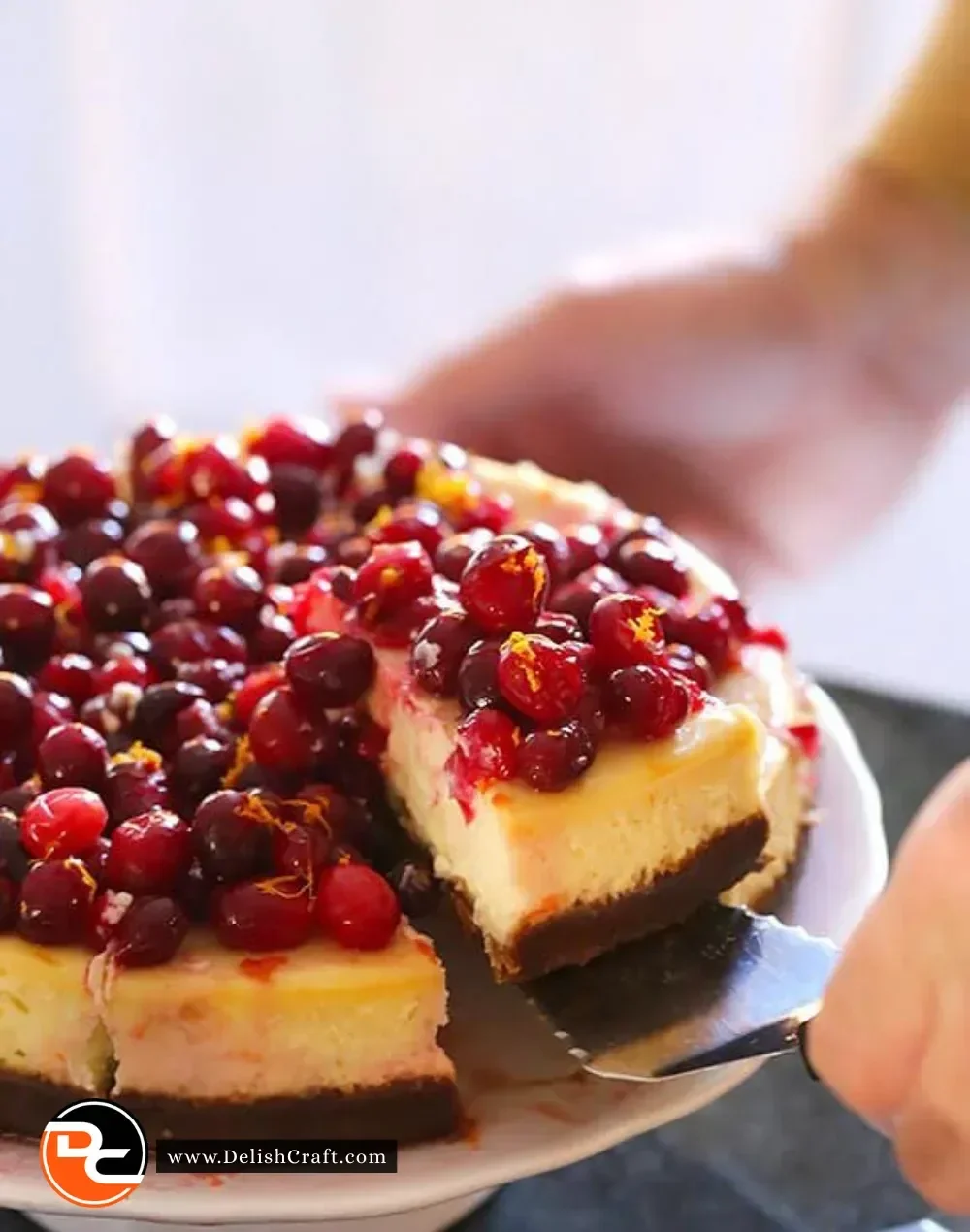 Delicious Cranberry Orange Cheesecake topped with fresh cranberries and orange zest