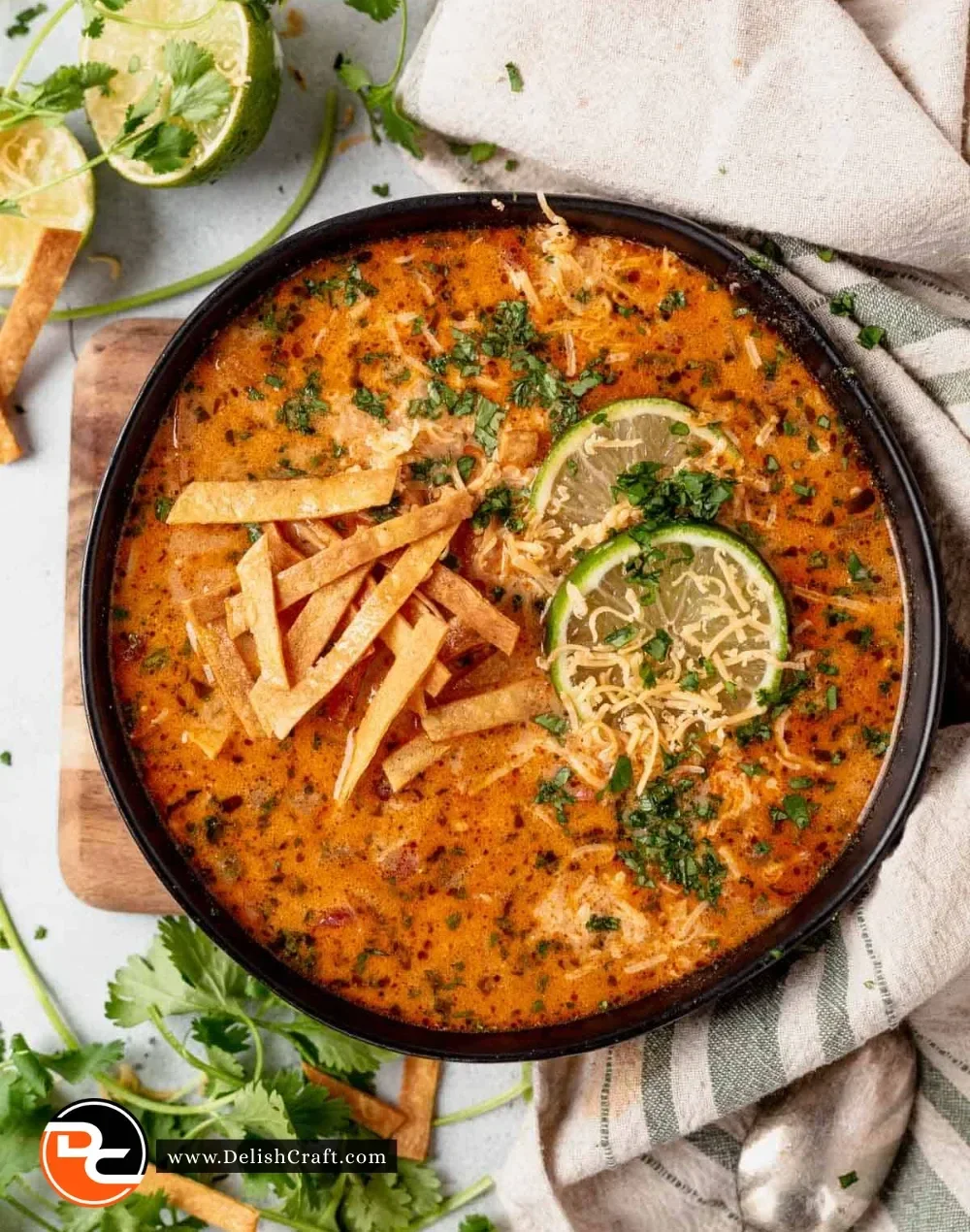 Bowl of creamy chicken tortilla soup topped with crispy tortillas and fresh herbs.