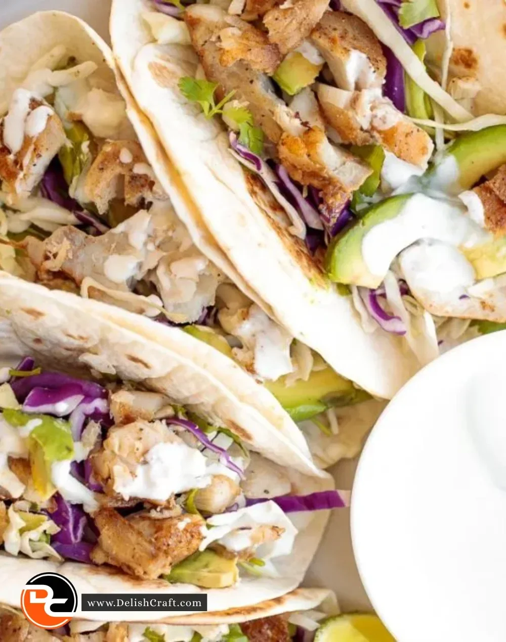 Fish tacos topped with lime crema served on a plate
