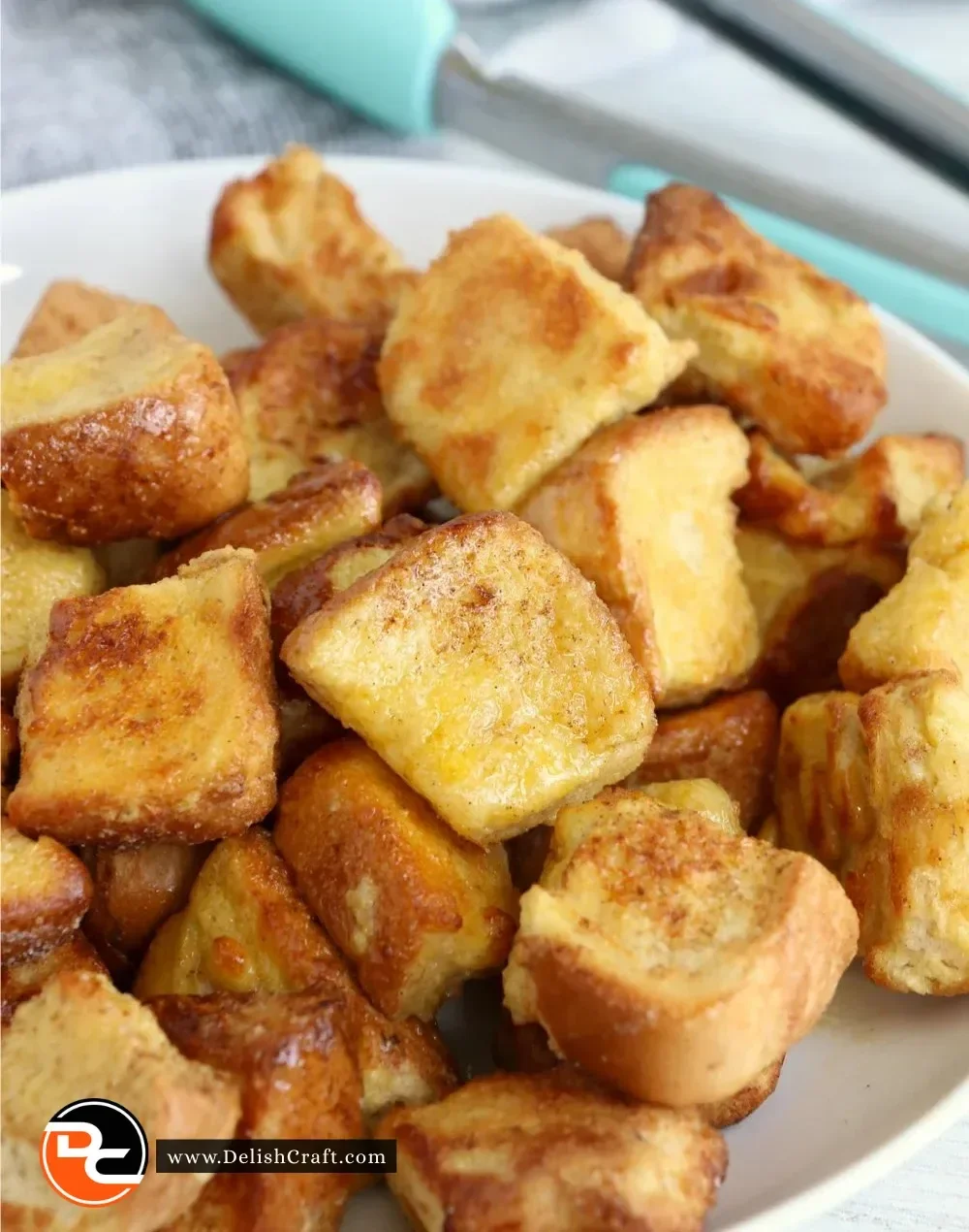 Delicious Ninja Foodi French Toast Bites served on a plate with syrup and fruit.