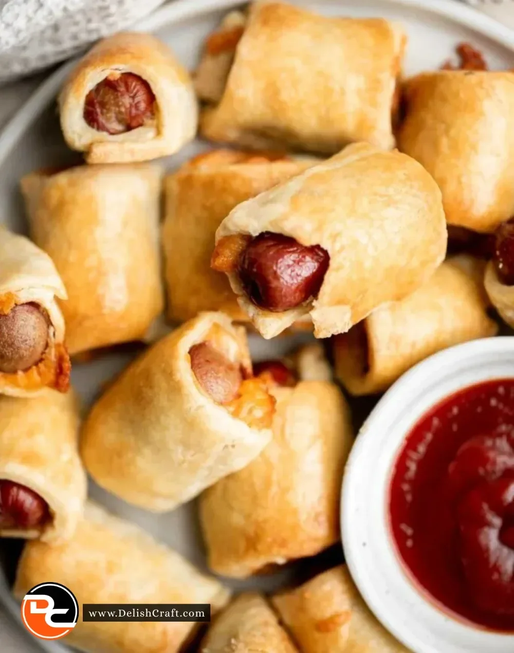 Close-up of homemade pigs in a blanket served on a platter.