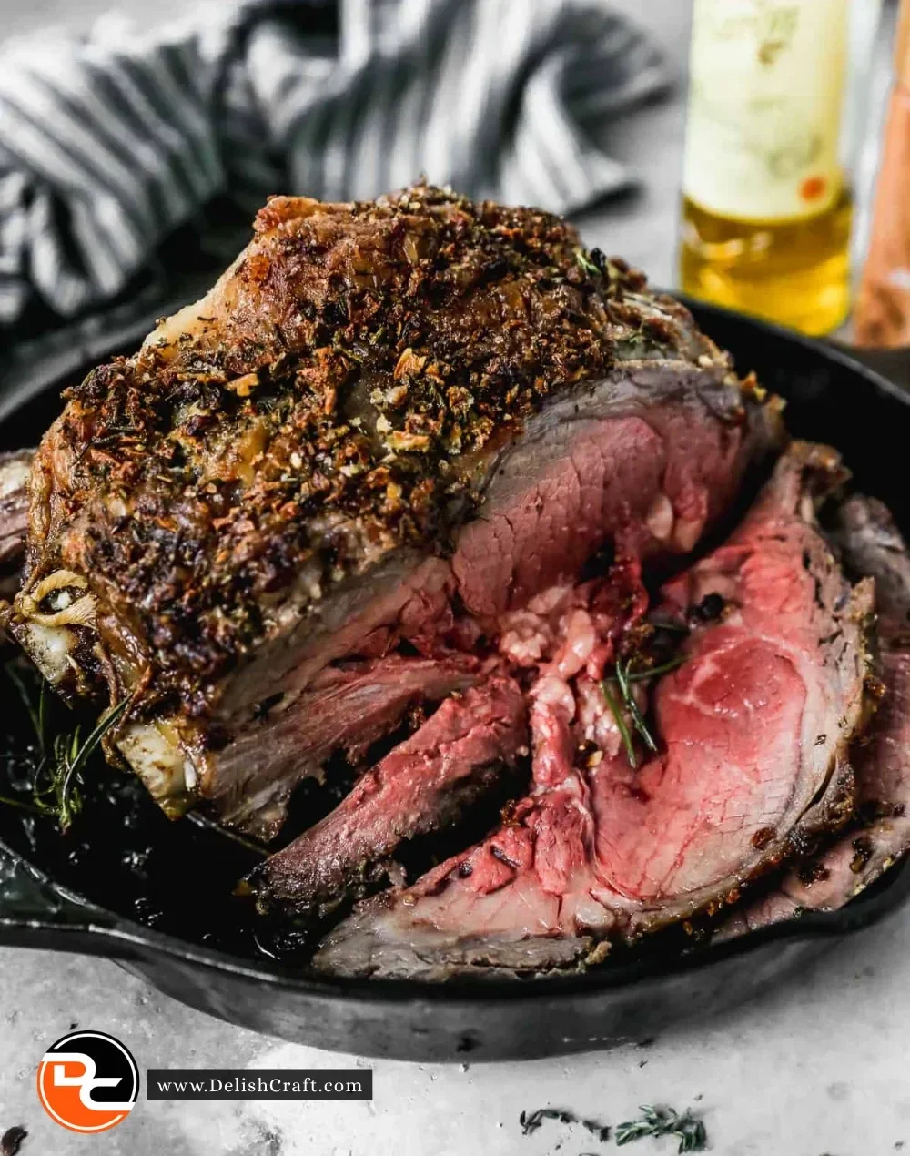 A perfectly cooked prime rib with rosemary and garlic seasoning on a wooden cutting board.