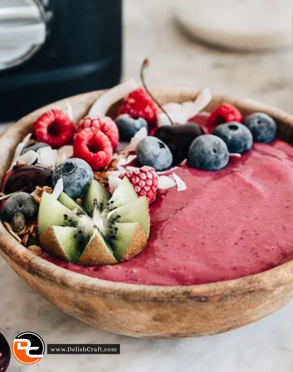 Delicious raspberry smoothie bowl topped with fresh berries and granola