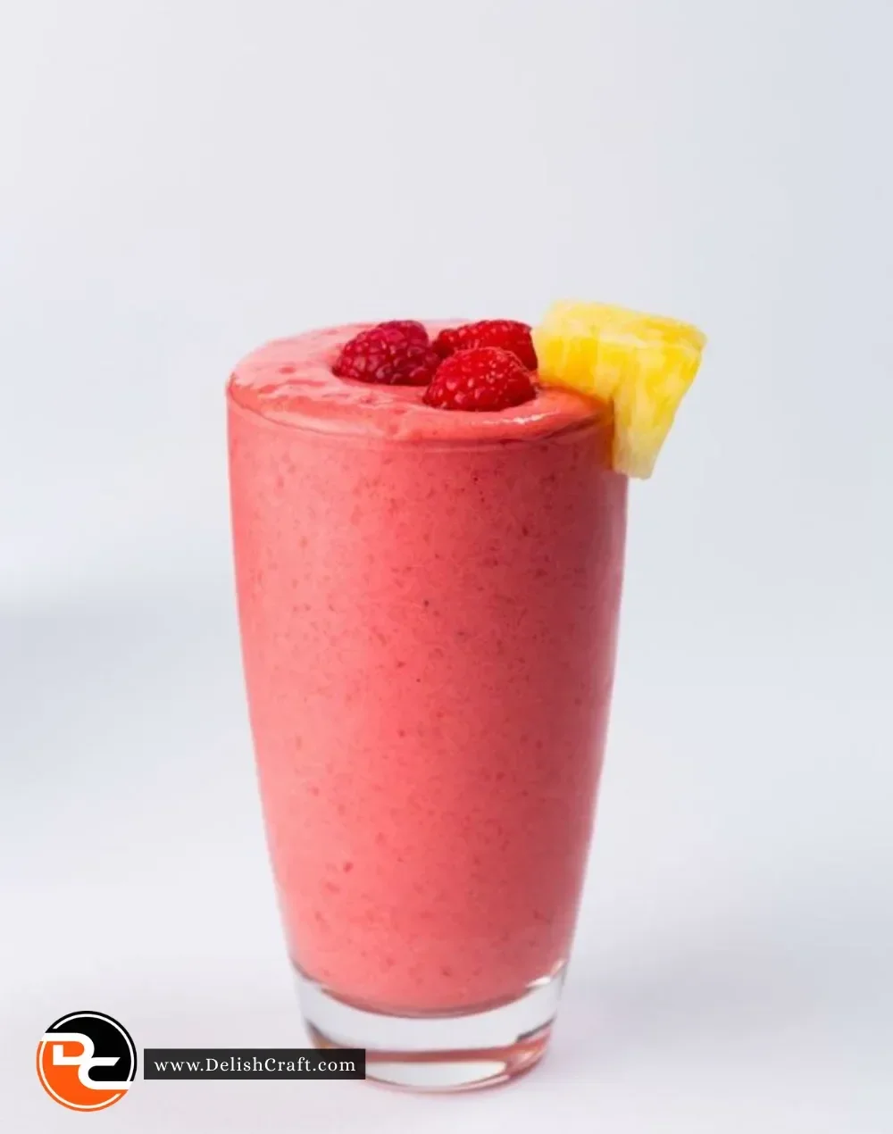 A colorful Razzle Dazzle Smoothie in a glass topped with fresh fruits.