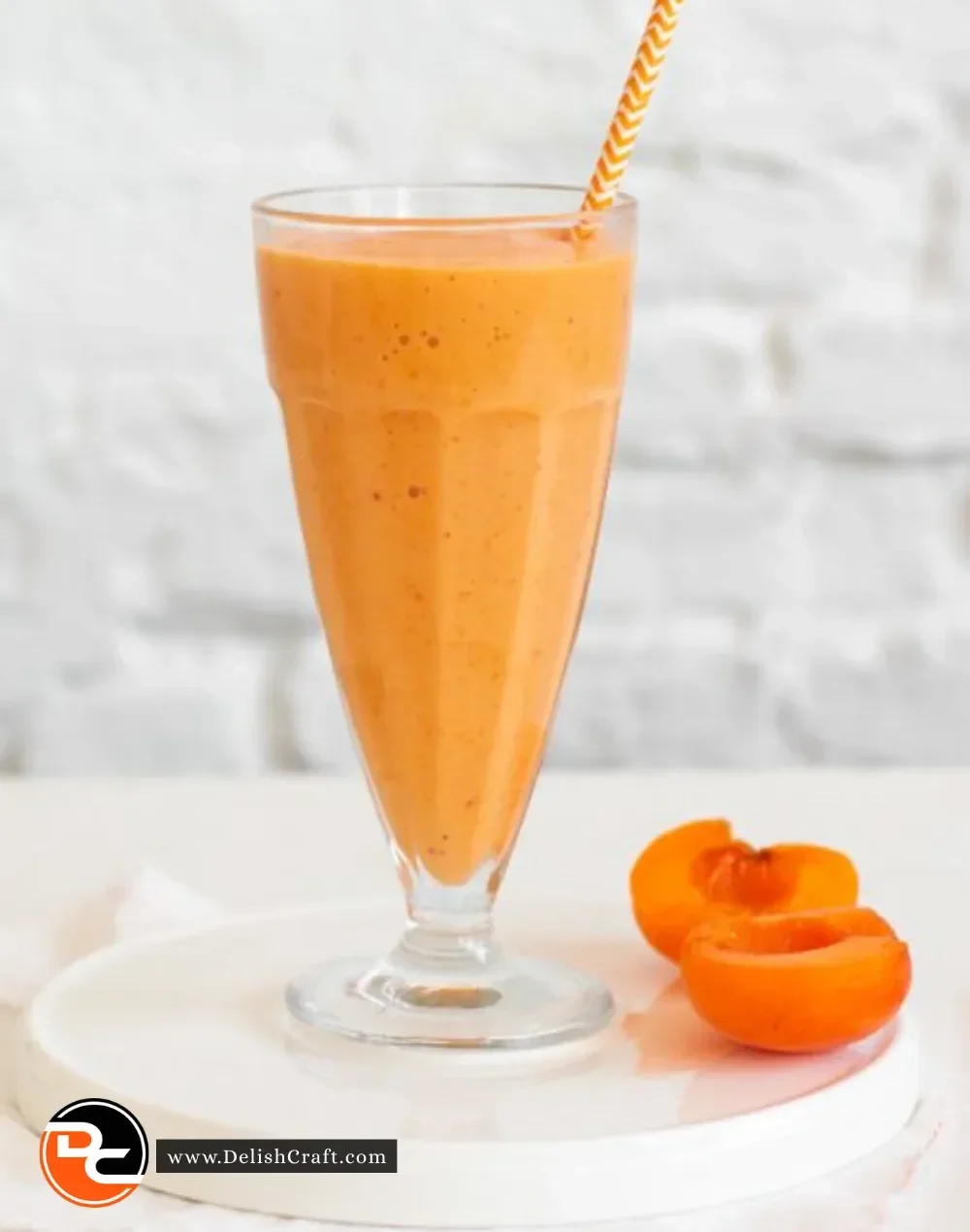 Creamy roasted apricot smoothie in a glass with fresh apricots and mint garnish