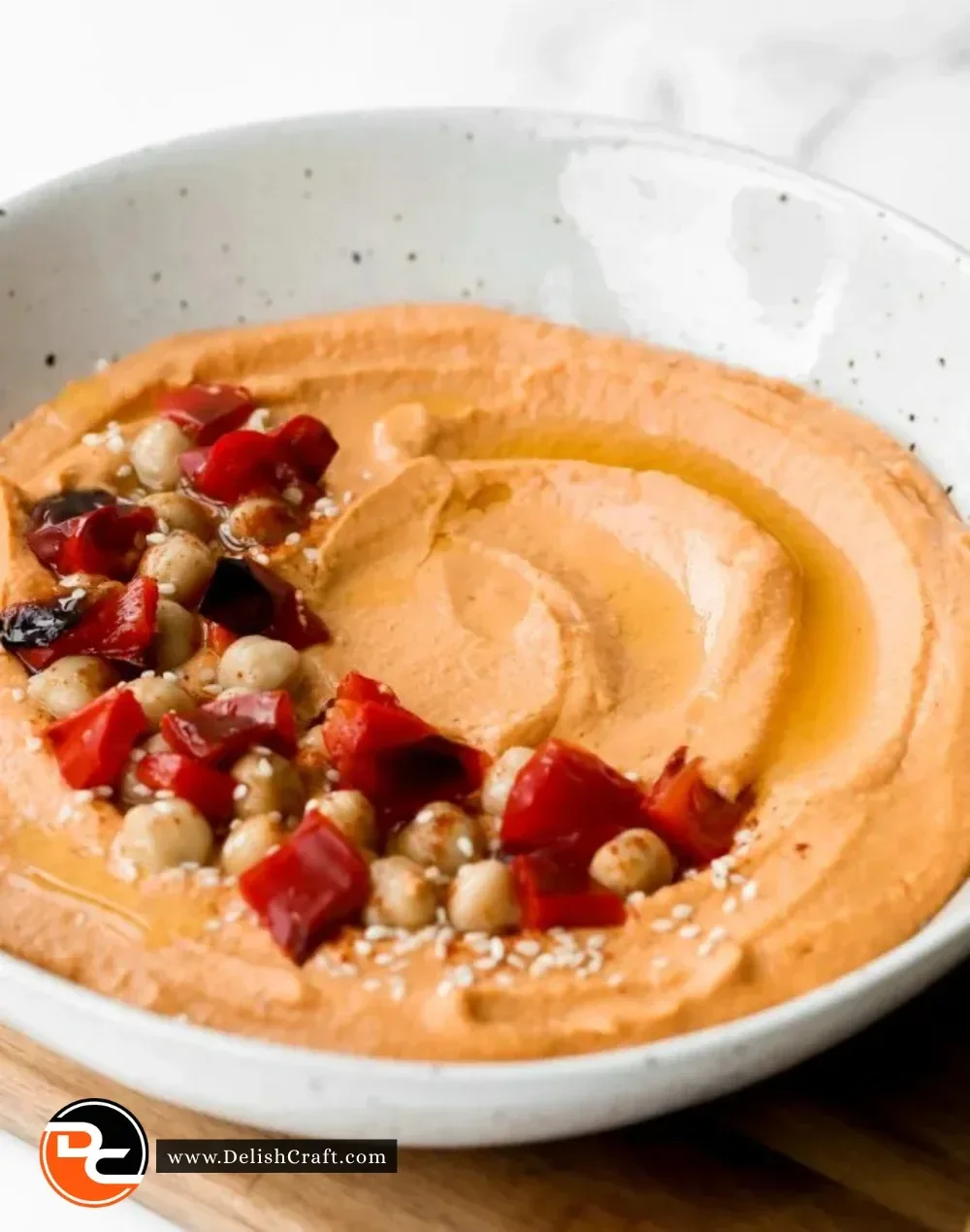 Bowl of delicious roasted red pepper hummus with pita chips and vegetables