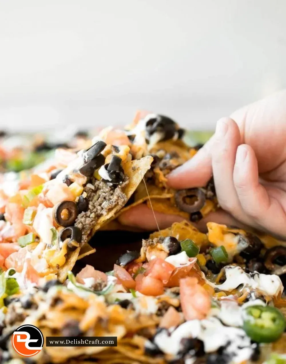 Delicious sheet pan nachos topped with cheese, jalapenos, and guacamole.