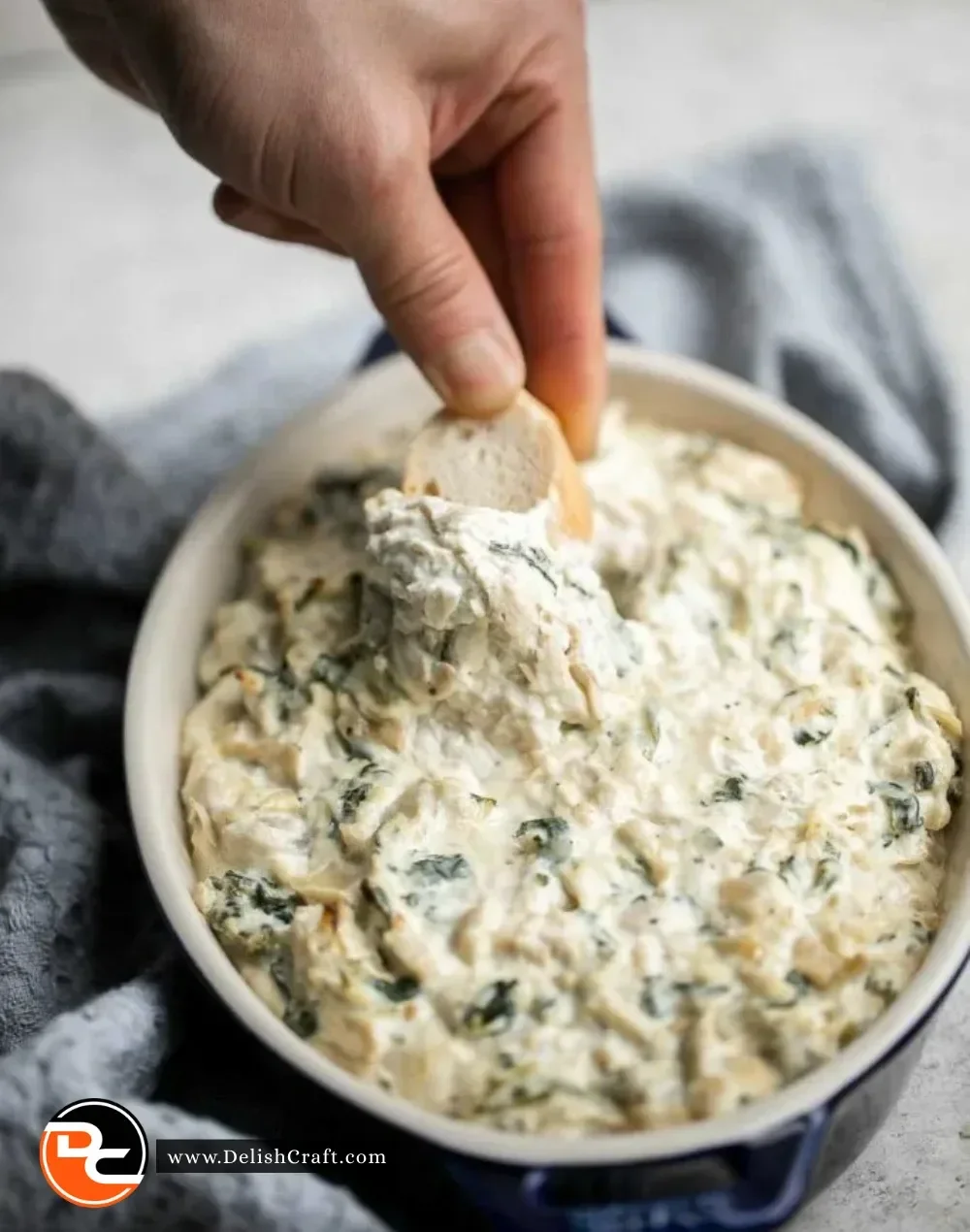 Delicious and creamy Spinach Artichoke Dip served in a bowl with chips.