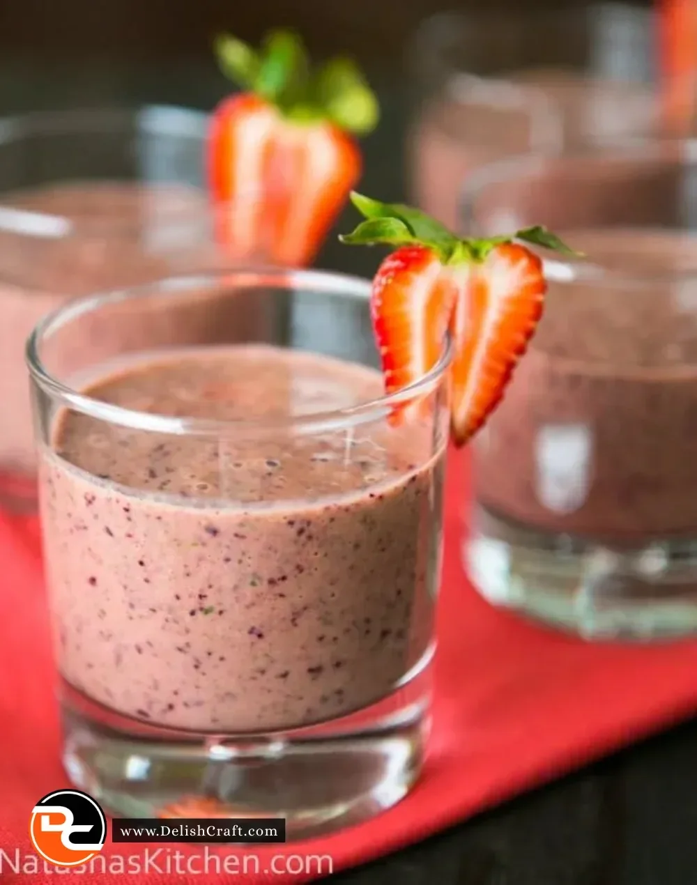 Strawberry spinach smoothie in a glass with fresh strawberries and spinach leaves