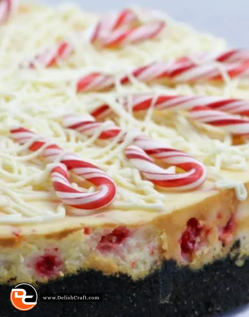A slice of white chocolate peppermint cheesecake topped with chocolate shavings and mint.