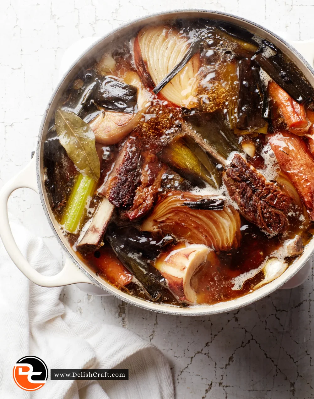 A warming bowl of homemade bone broth filled with vegetables and herbs.