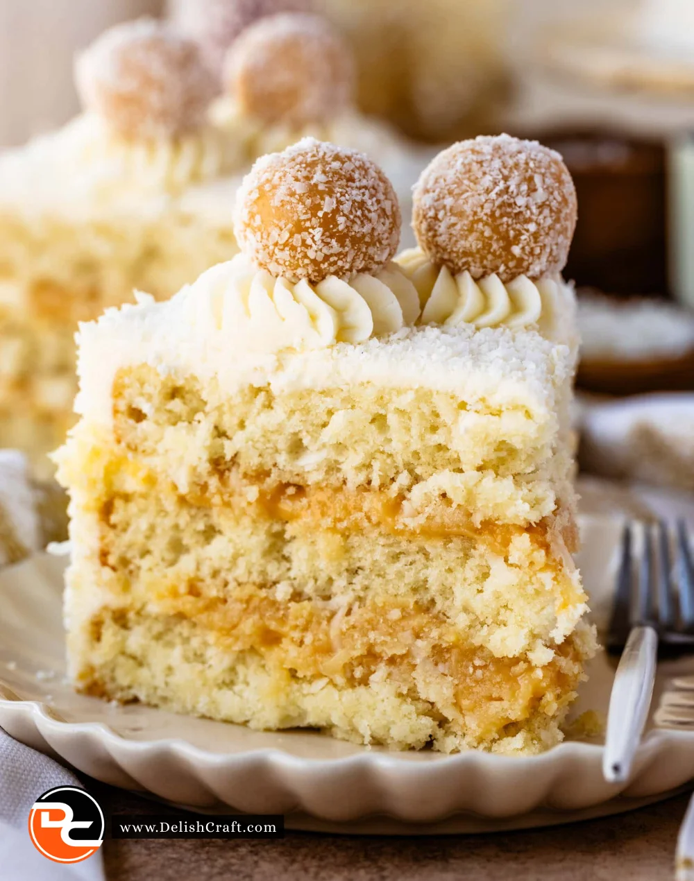 Delicious slice of moist Coconut Cake on a plate with coconut flakes