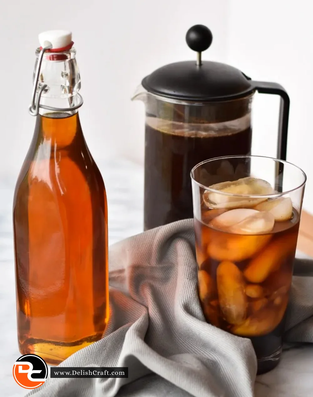 Homemade coffee syrup served in a glass with coffee beans and a spoon.