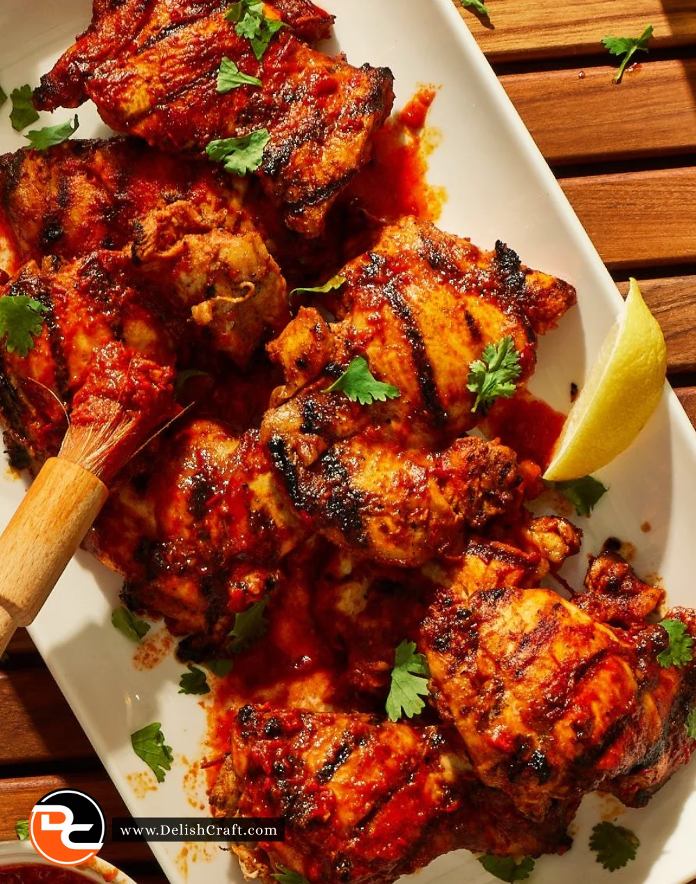 Delicious harissa grilled chicken on a serving platter, garnished with herbs.