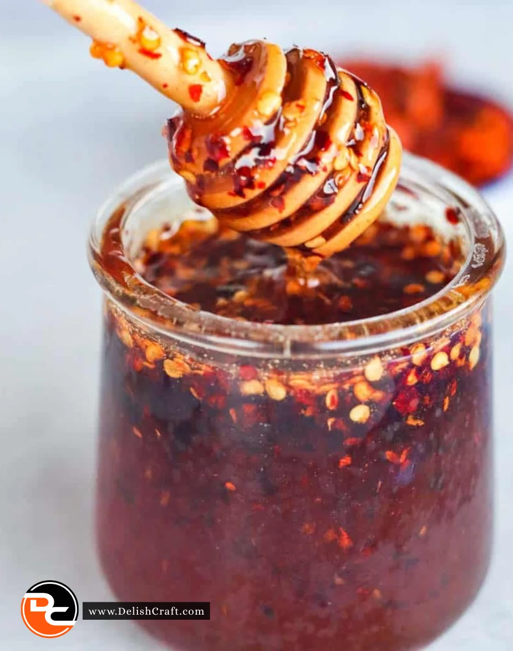 Jar of hot honey with chili peppers, ideal for drizzling on food.