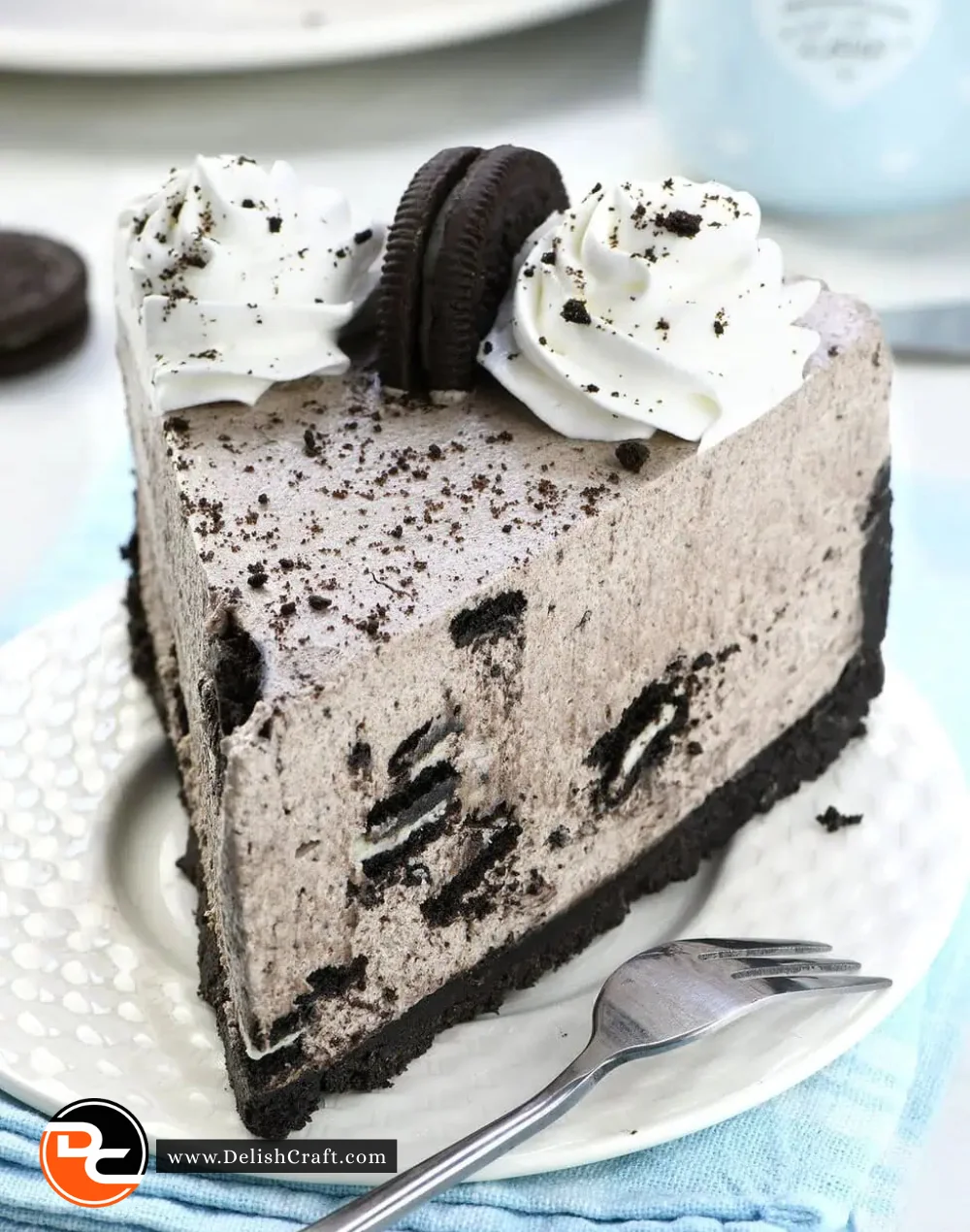 Delicious no bake Oreo cheesecake topped with crushed Oreos and chocolate drizzle.