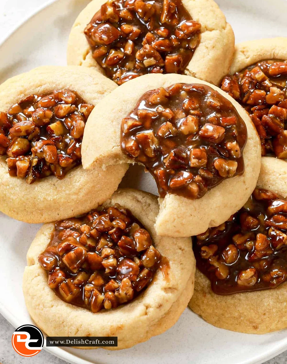 Pecan pie cookies topped with pecans on a wooden table