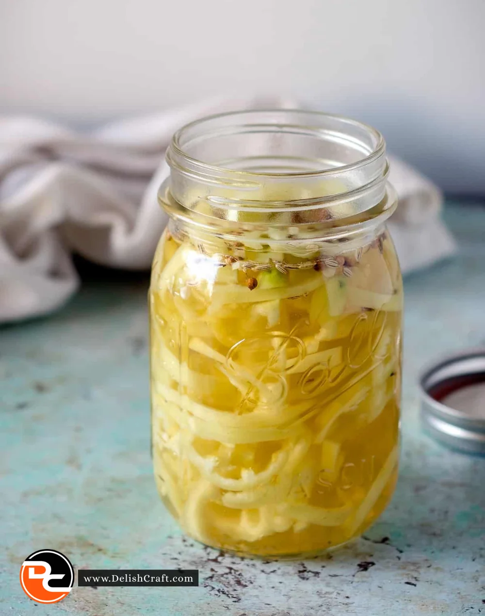 Jar of pickled banana peppers on a wooden table