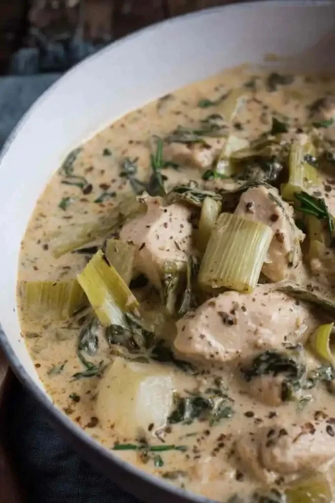 Delicious chicken with leeks served on a plate, garnished with herbs