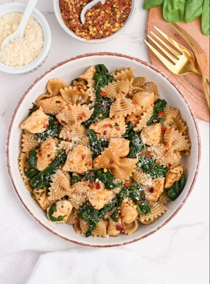 Healthy chicken spinach pasta dish served in a bowl