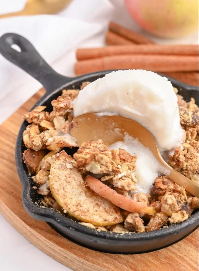 High Protein Apple Crumble served in a bowl with fresh apples and oats
