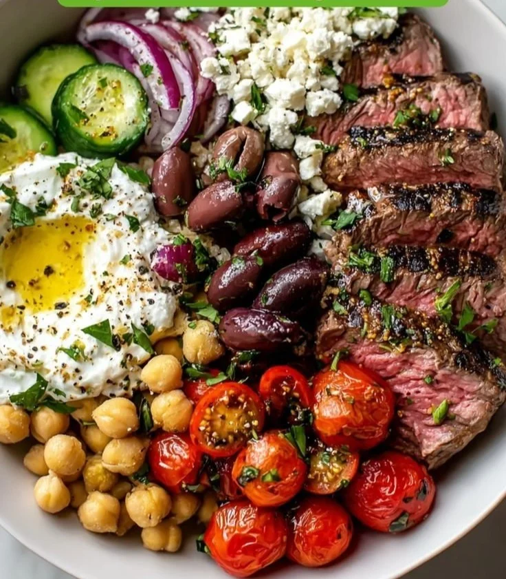 Mediterranean steak bowl with grilled steak, vegetables, and dressing