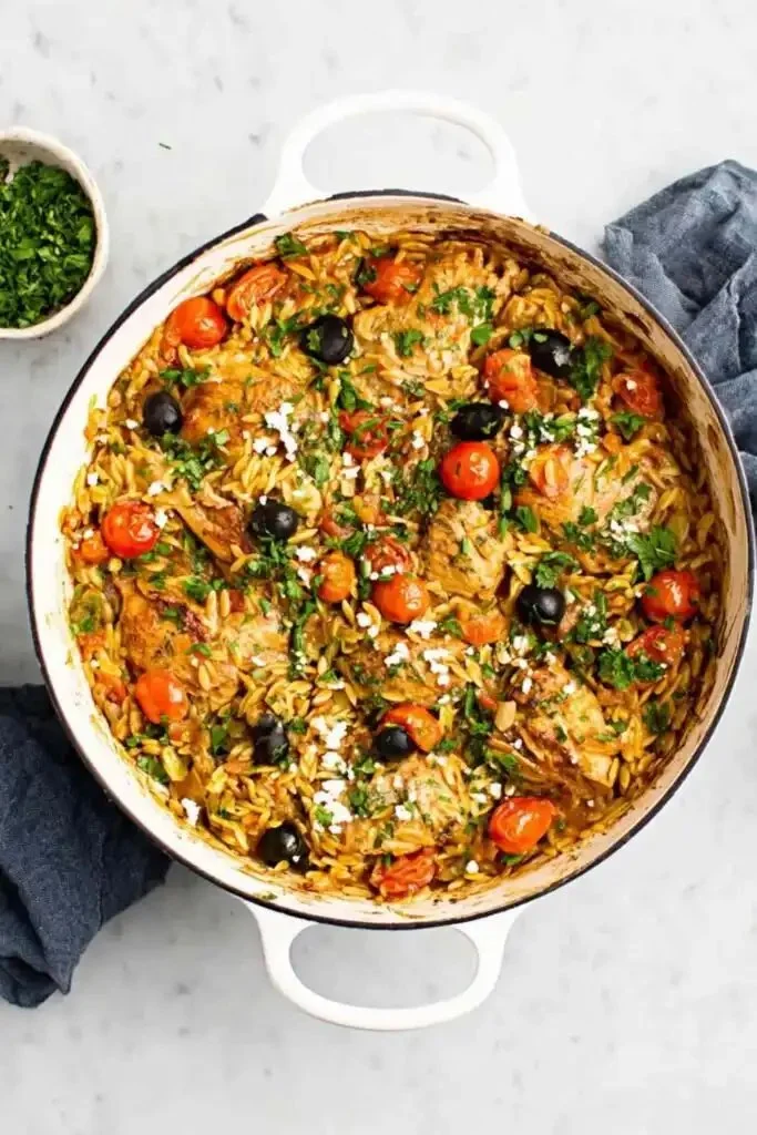 Delicious Skillet Chicken Orzo served in a pan with fresh herbs.