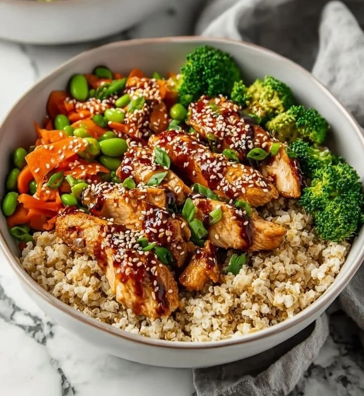 Delicious Sticky Chicken Bowls garnished with fresh vegetables and sesame seeds
