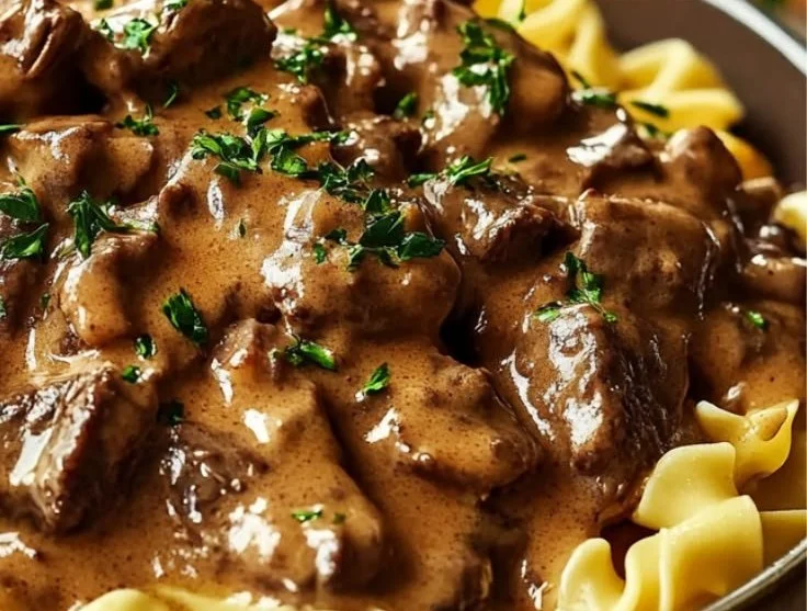 Slow cooker Beef Stroganoff served with creamy sauce and noodles