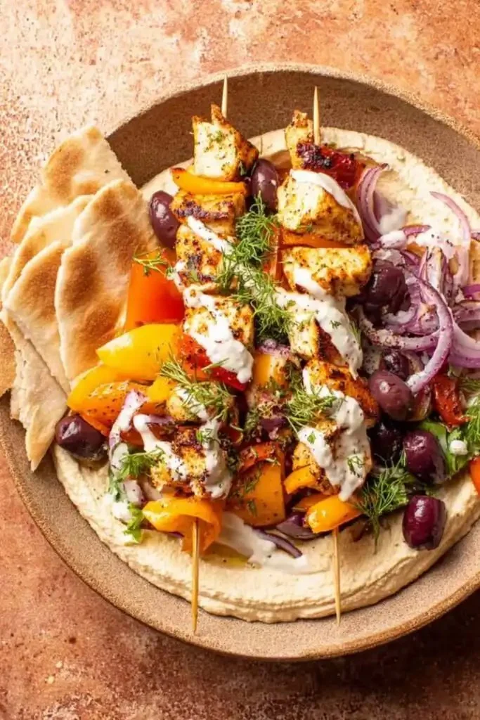 Delicious homemade chicken souvlaki served with tzatziki and fresh vegetables.