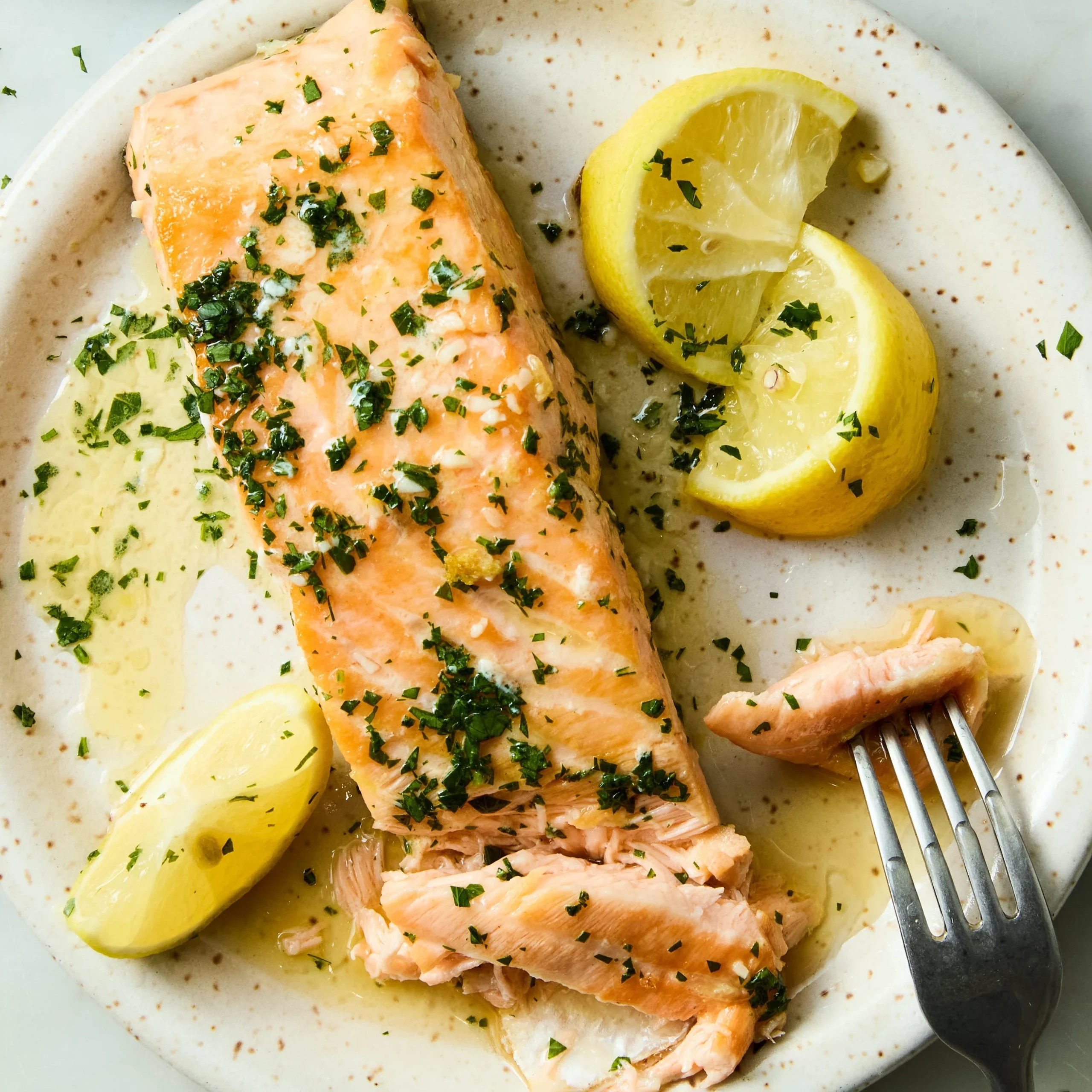 Plate of Lemon Brown Butter Salmon garnished with herbs and lemon slices